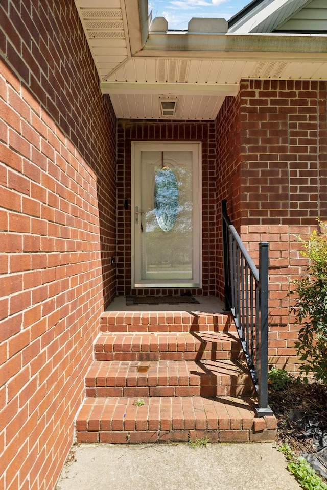 property entrance featuring brick siding