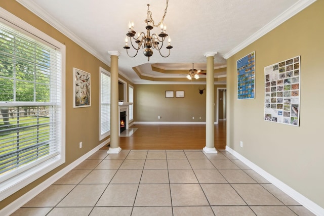 unfurnished dining area featuring ornate columns, ceiling fan with notable chandelier, and light tile patterned flooring