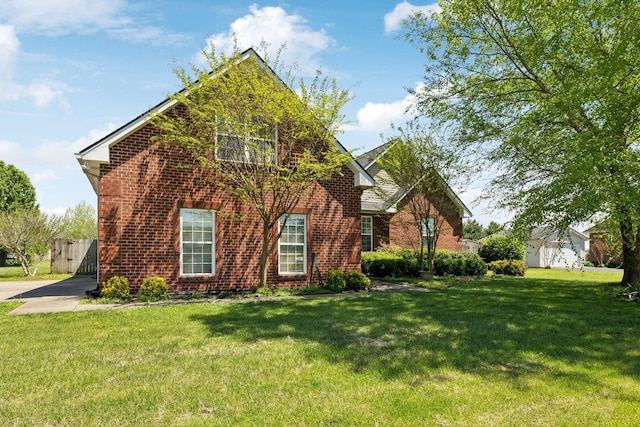 view of front of house with a front yard and brick siding