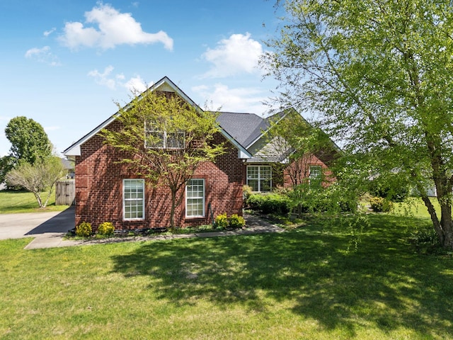 traditional home featuring a front lawn and brick siding