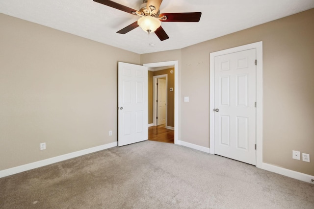 unfurnished bedroom with a ceiling fan, carpet floors, and baseboards