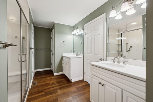 bathroom with a stall shower, crown molding, and a sink