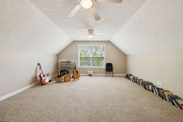 recreation room featuring a textured ceiling, a ceiling fan, baseboards, and carpet floors