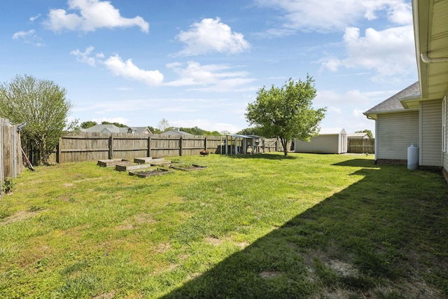 view of yard with a garden, a shed, an outbuilding, and a fenced backyard