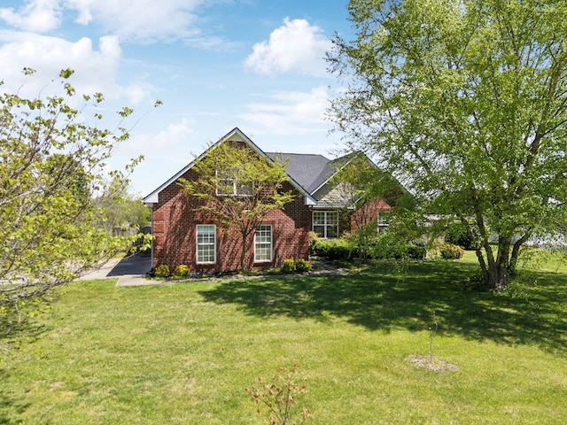 view of front of home featuring brick siding and a front yard