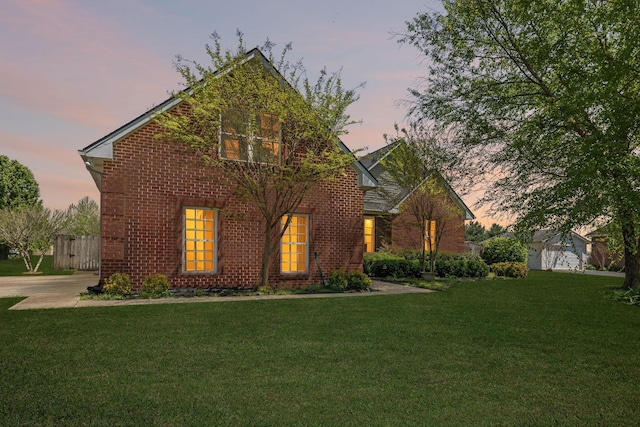 traditional-style house with brick siding and a yard