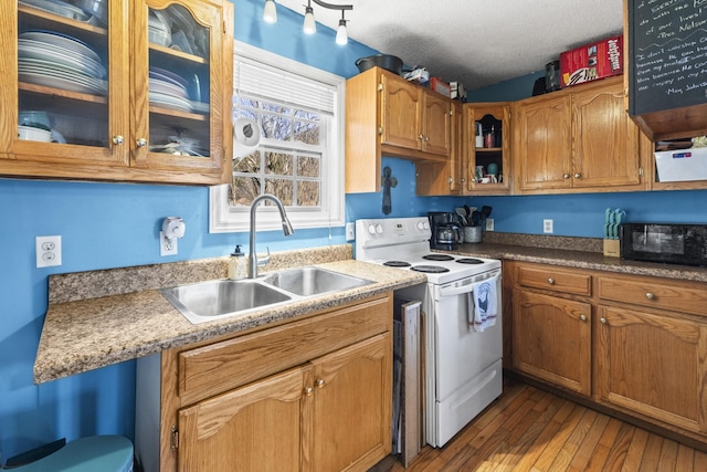 kitchen with electric range, hardwood / wood-style floors, a textured ceiling, black microwave, and a sink