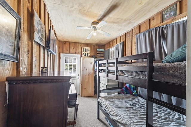 bedroom with carpet floors and wood walls