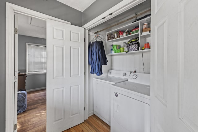 laundry area featuring washing machine and dryer, laundry area, baseboards, light wood finished floors, and attic access