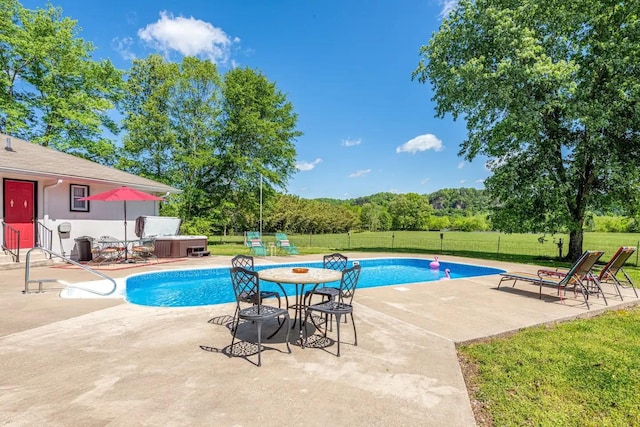 view of pool with a patio area, a lawn, a hot tub, and fence