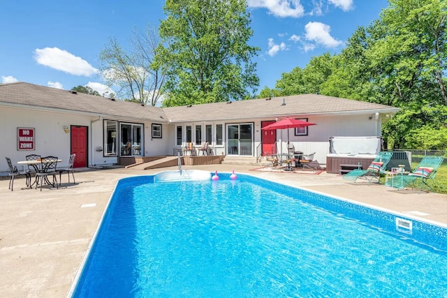 rear view of property featuring a patio area, fence, and a fenced in pool