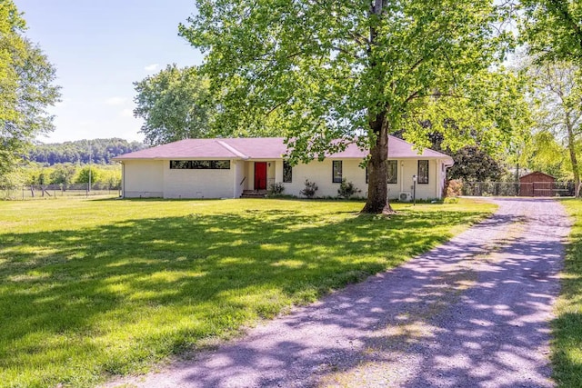 ranch-style home with a front yard and fence