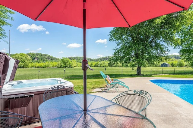 view of pool featuring a patio area, a yard, a hot tub, and fence