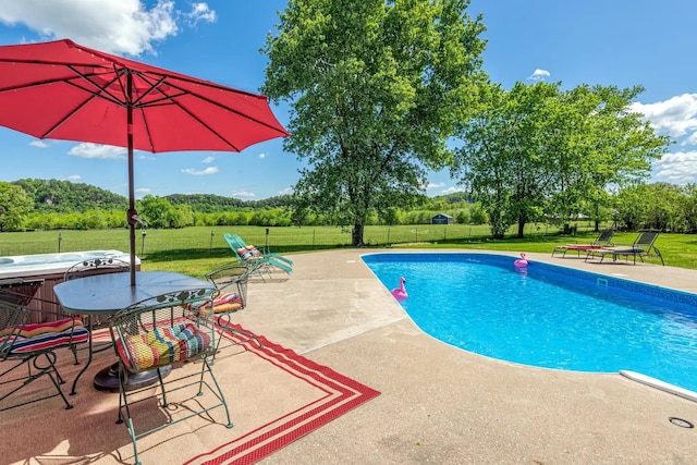 view of pool featuring fence, a lawn, and a patio