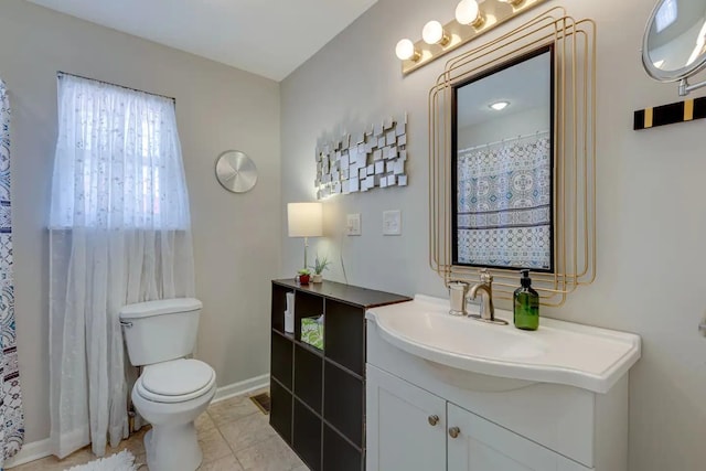 bathroom with baseboards, vanity, toilet, and tile patterned floors