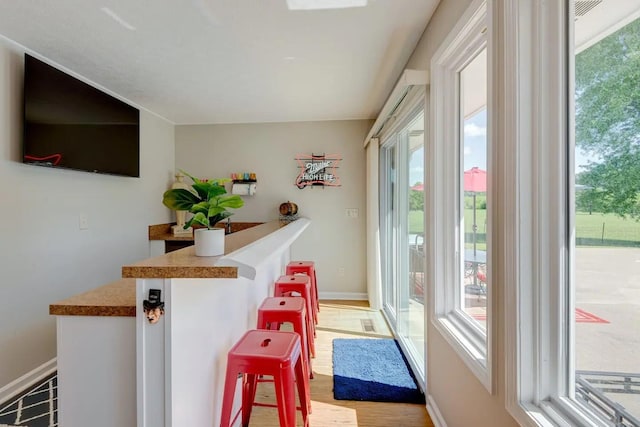 doorway to outside featuring baseboards and wood finished floors