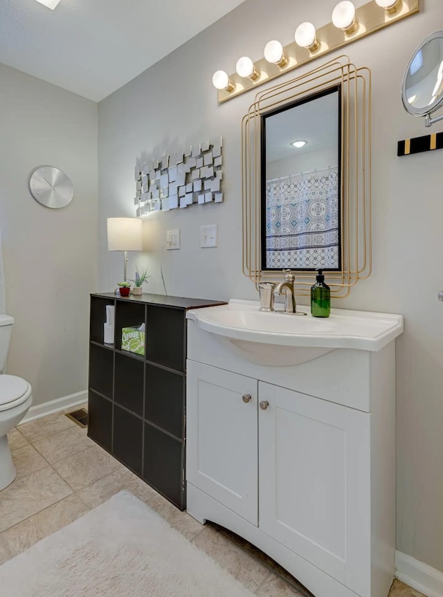 full bathroom with vanity, toilet, and baseboards