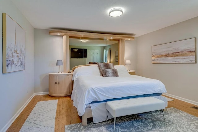 bedroom with light wood-type flooring and baseboards