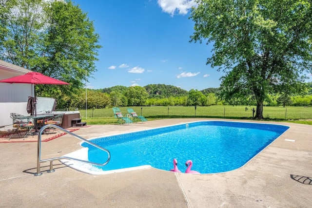 view of swimming pool featuring a yard, fence, a fenced in pool, and a patio