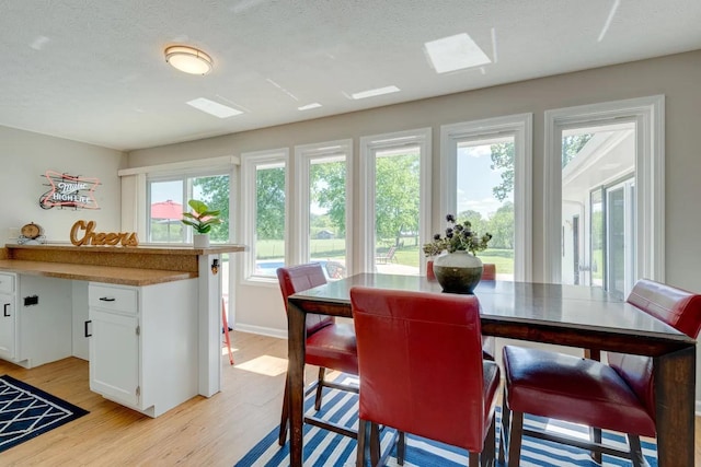 dining room with light wood-style floors and a textured ceiling