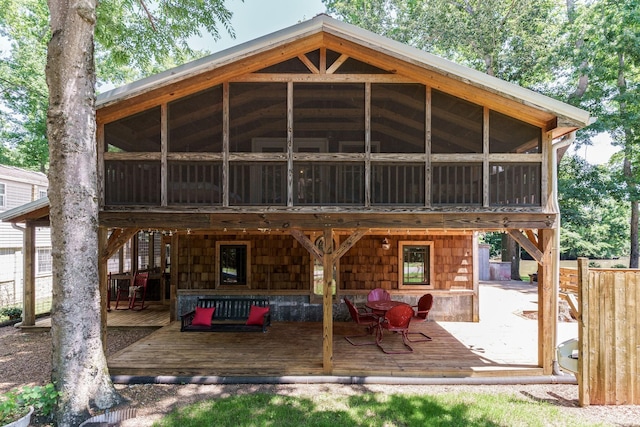 rear view of property featuring a wooden deck and a sunroom