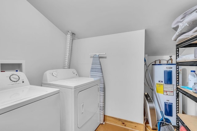 laundry room with laundry area, water heater, and washer and clothes dryer