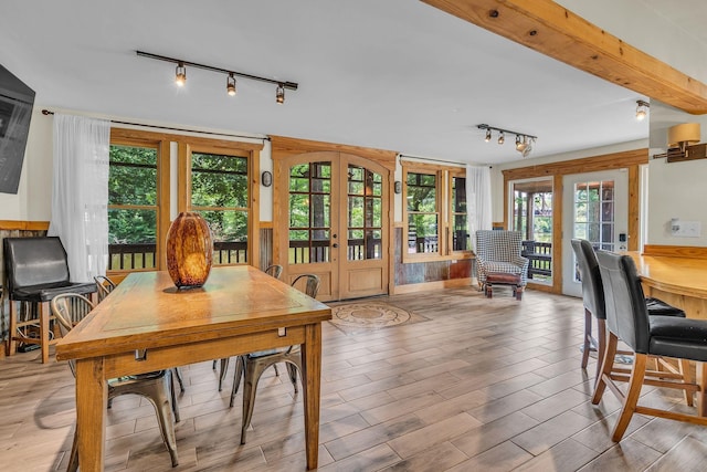 dining area with french doors, wood finished floors, and beam ceiling