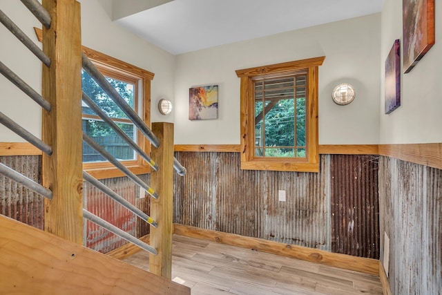 interior space with a wainscoted wall, wood finished floors, and wooden walls