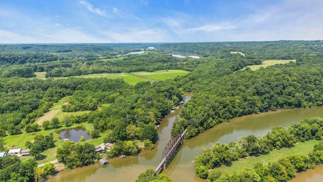 birds eye view of property featuring a water view and a wooded view