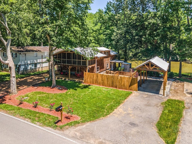 view of yard with fence, aphalt driveway, and a detached carport