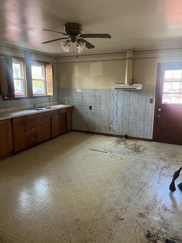 kitchen featuring light countertops, a healthy amount of sunlight, and wallpapered walls