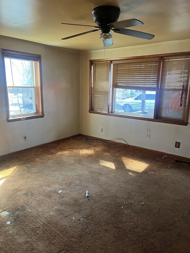 carpeted spare room with visible vents, ceiling fan, and baseboards