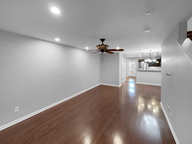 unfurnished living room with ceiling fan, recessed lighting, dark wood finished floors, and baseboards