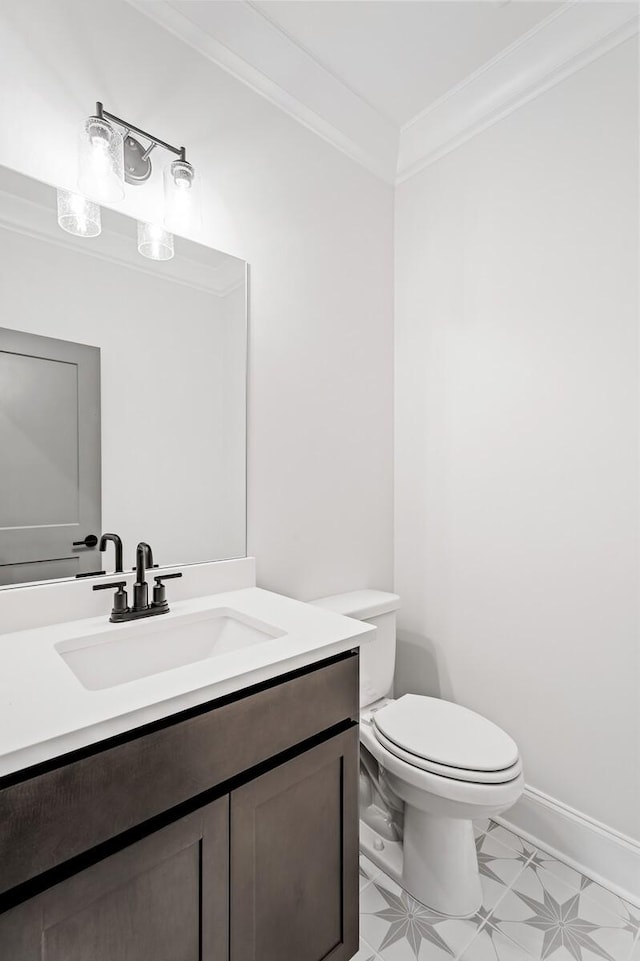 bathroom with toilet, baseboards, ornamental molding, and vanity