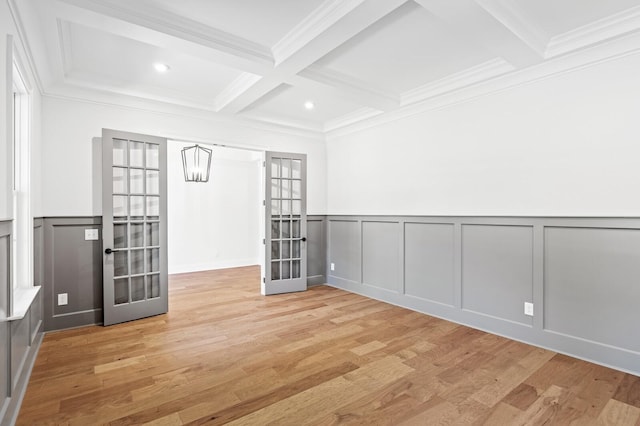 unfurnished room featuring light wood-type flooring, french doors, beamed ceiling, and coffered ceiling