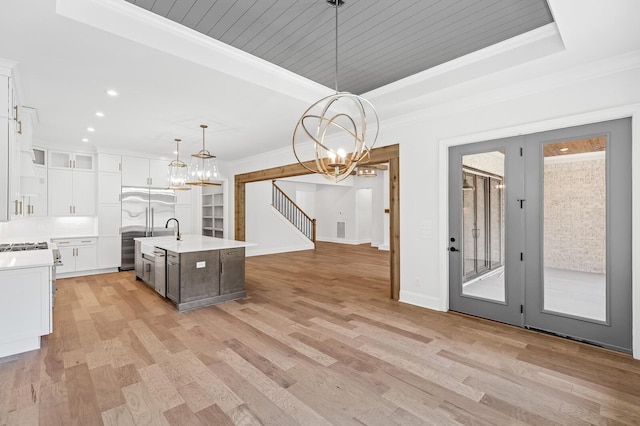 kitchen with white cabinets, a tray ceiling, light countertops, and crown molding