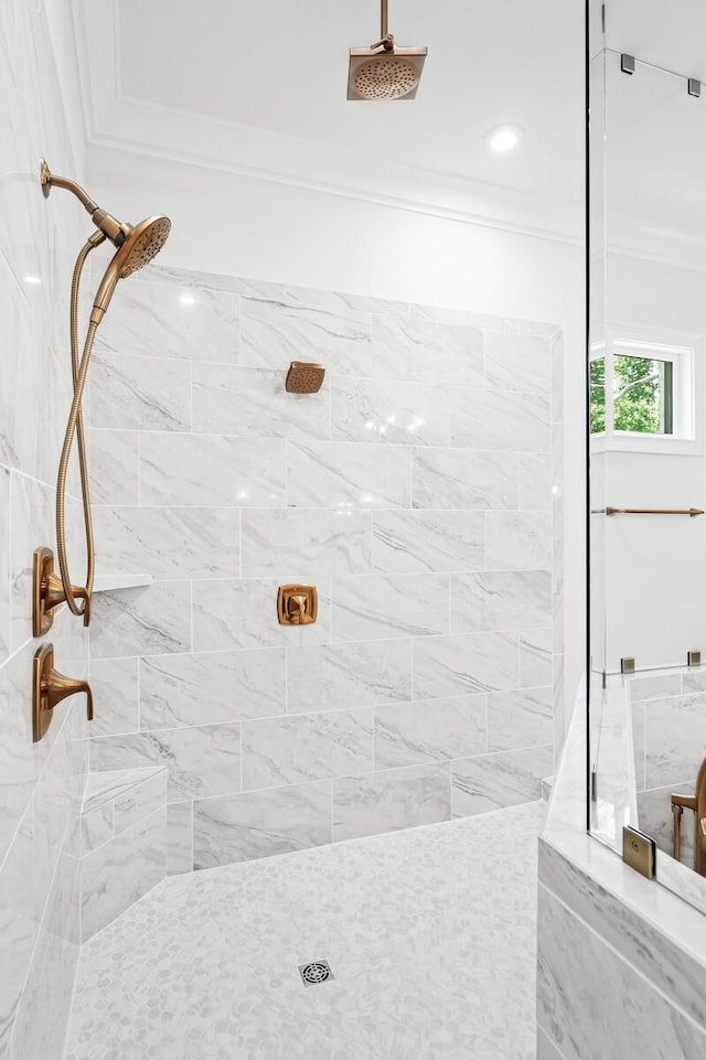 bathroom featuring ornamental molding and tiled shower