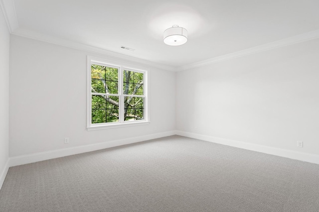 carpeted empty room with baseboards, visible vents, and crown molding