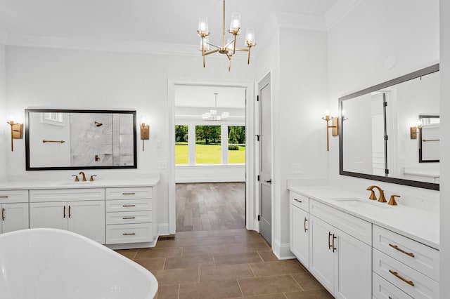 full bath with ornamental molding, a soaking tub, a sink, and an inviting chandelier