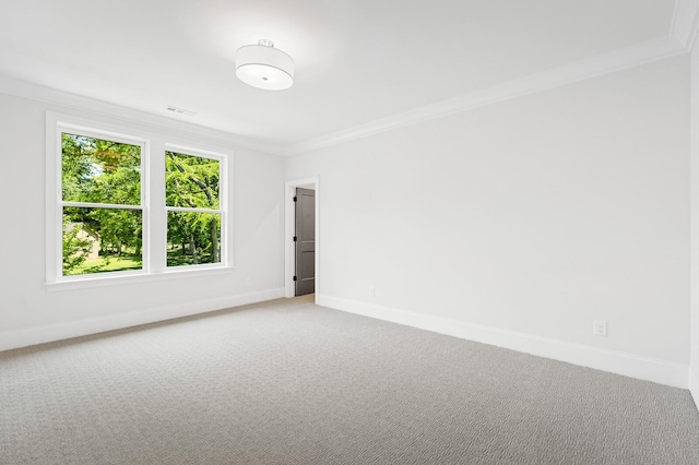 carpeted empty room featuring ornamental molding and baseboards