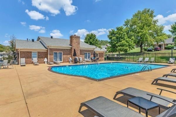 pool with a patio and fence