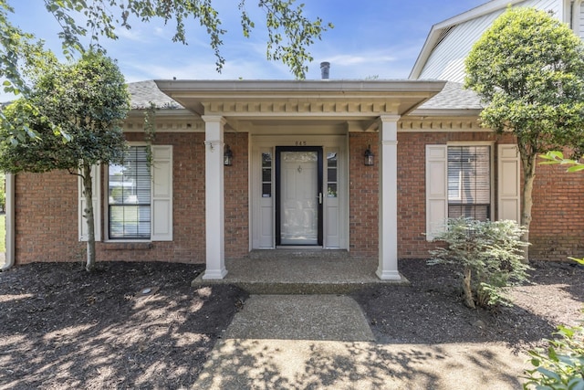 property entrance featuring brick siding