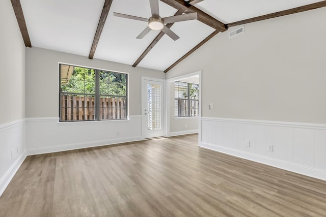 spare room featuring a wealth of natural light, visible vents, ceiling fan, and wood finished floors