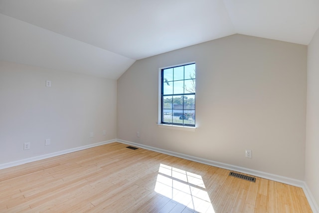 additional living space featuring lofted ceiling, wood finished floors, and visible vents