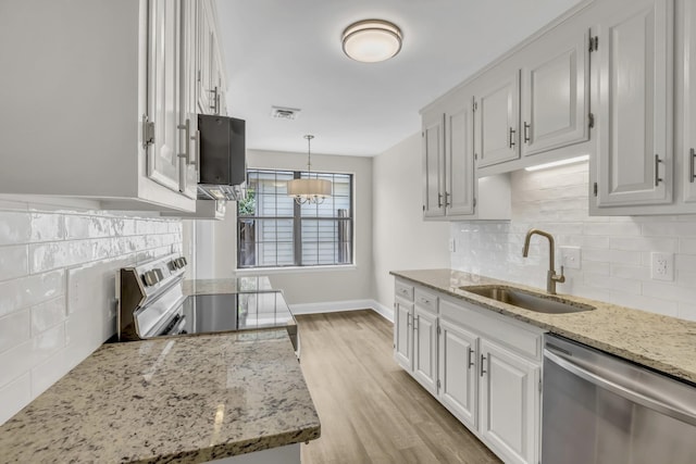 kitchen featuring visible vents, electric stove, dishwasher, light wood-type flooring, and a sink