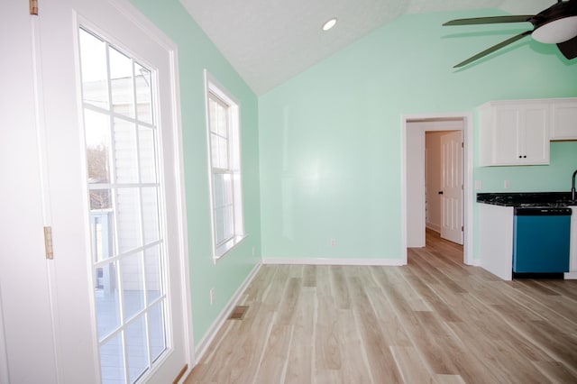 unfurnished dining area featuring light wood finished floors, lofted ceiling, visible vents, ceiling fan, and baseboards