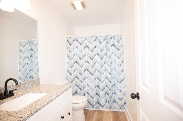 full bathroom with curtained shower, toilet, wood finished floors, visible vents, and vanity