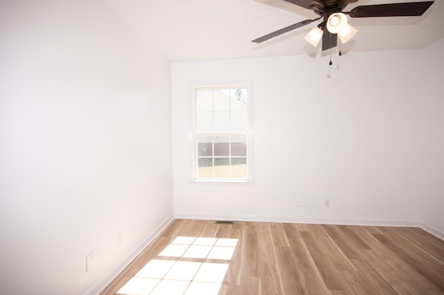 empty room with a ceiling fan, light wood-type flooring, and baseboards