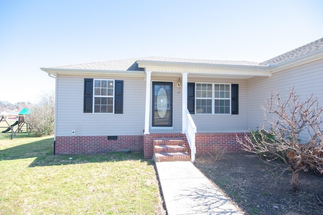 property entrance featuring a yard, crawl space, and roof with shingles