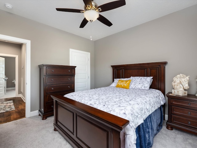 bedroom with light carpet, ceiling fan, and baseboards